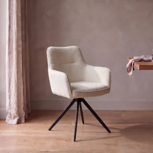 Stoel Lara in off white met armleuningen en zwart onderstel aan een houten eettafel